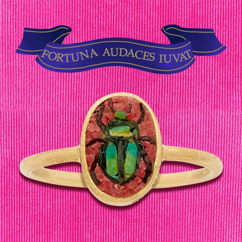 Scarabeo Ring top view on a pink background with a blue banner